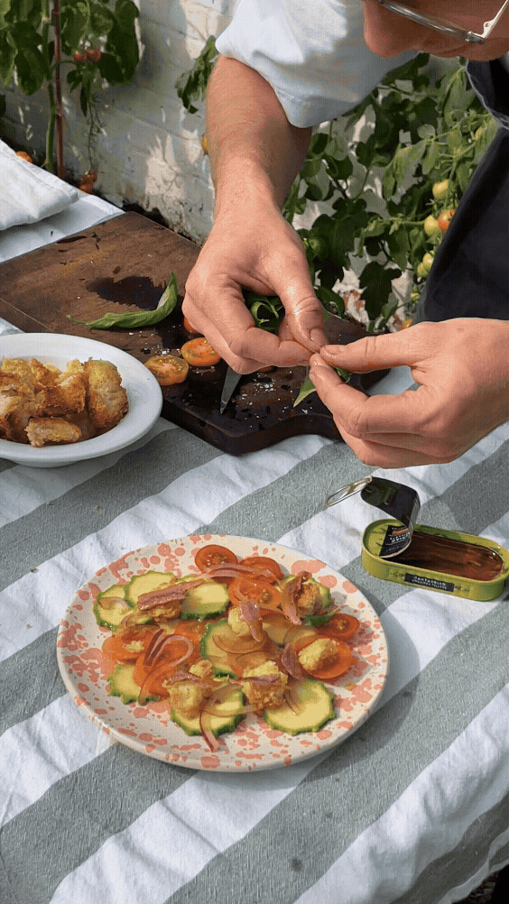 Panzanella made with courgette and summer tomatoes, topped with anchovies and toasted bread