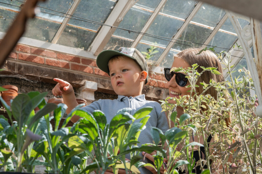 Mother and child in the greenhouse among the plants